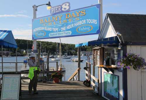 A waterfront scene featuring a sign for "Balmy Days Cruises" and a person in a bright vest near a ticket booth.