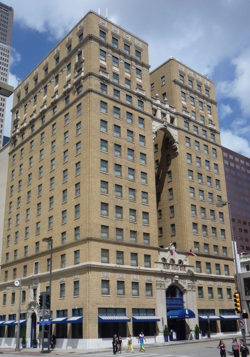 Historic building with a unique archway design, featuring multiple floors and decorative elements, set against a blue sky.