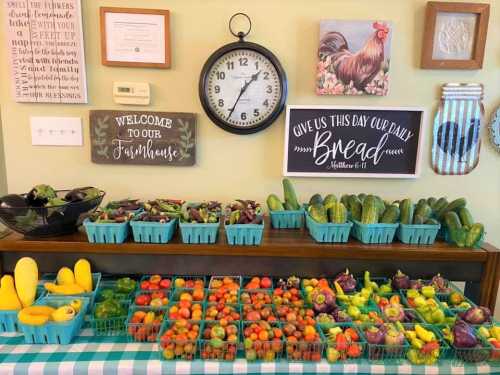 A colorful display of fresh fruits and vegetables in baskets, with decorative signs and a clock on the wall.