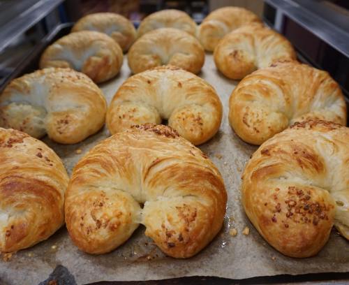 Freshly baked croissants arranged on a baking tray lined with parchment paper.