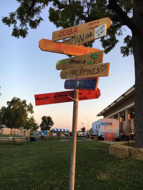 A wooden signpost with directional arrows pointing to various countries, including Cuba, Japan, Germany, Jamaica, and the Philippines.