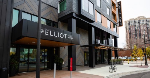 Exterior view of the Elliot Park Hotel, featuring modern architecture and a bike parked outside.