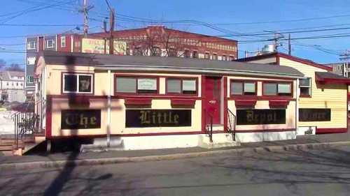 A colorful building with a sign reading "The Little Depot Diner," set against a clear blue sky.