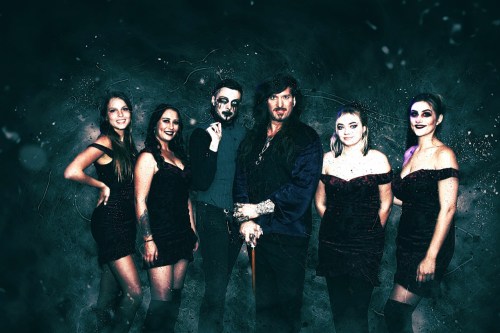A group of six people in dark outfits poses together against a moody, textured background.