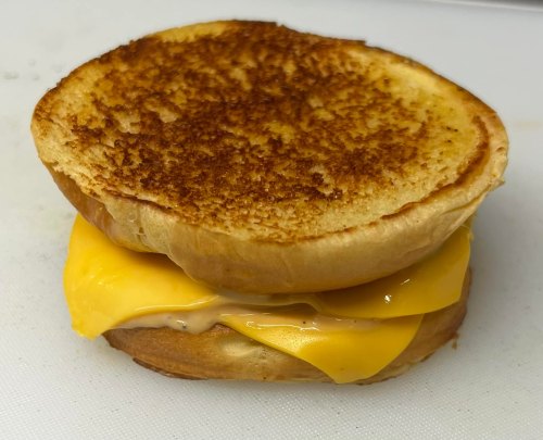 A toasted sandwich with melted cheese oozing between two golden-brown bread slices.