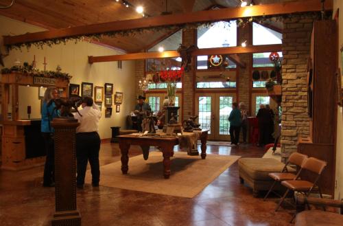 A spacious interior with a reception area, wooden decor, and people engaging in conversation and browsing items.