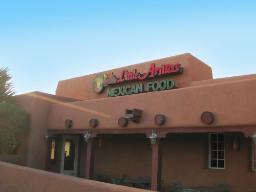 Exterior of Little Anitas Mexican Food restaurant with a warm, adobe-style building and colorful signage.