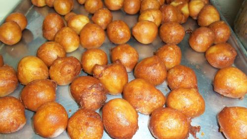 A tray filled with golden-brown, round fried dough balls, arranged closely together.