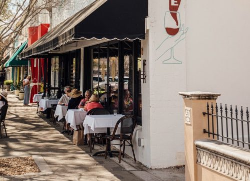 Exterior of a restaurant named "Josephine," featuring outdoor seating and a mural of a wine glass on the wall.