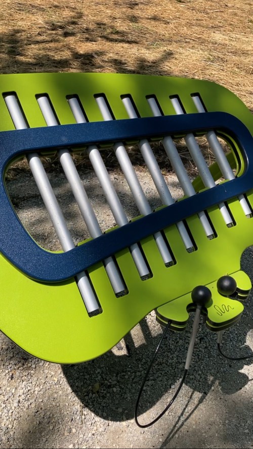 A colorful outdoor bench with a unique design, featuring a blue and green color scheme and attached headphones.