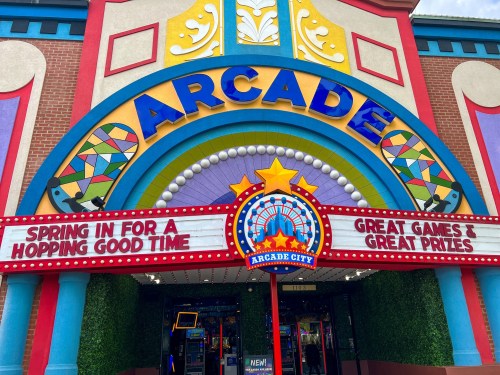 Colorful arcade entrance with a sign reading "Spring in for a Hopping Good Time" and "Great Games & Great Prizes."