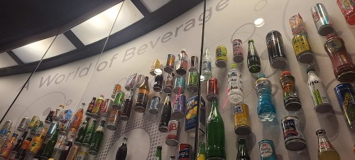 A display wall featuring a variety of beverage bottles and cans, labeled "A World of Beverage."