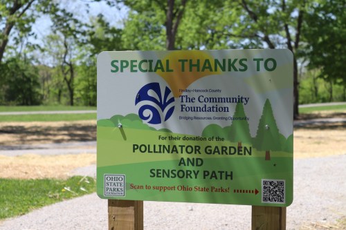 Sign thanking The Community Foundation for donating a pollinator garden and sensory path, with a QR code for support.