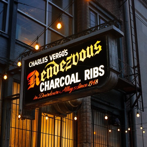 Sign for Charles Vergos' Rendezvous Charcoal Ribs, established in 1948, located in Downtown Alley, illuminated at night.
