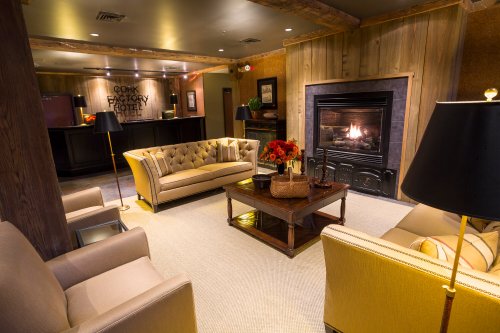 Cozy hotel lobby with a fireplace, plush seating, and warm lighting, creating an inviting atmosphere.