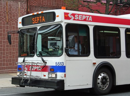 A SEPTA bus with a red and white design parked on a city street, displaying the route number on the front.