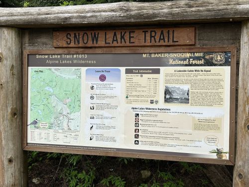 Trail sign for Snow Lake Trail #1013, featuring maps, trail information, and regulations for the Alpine Lakes Wilderness.