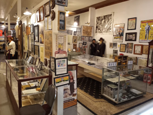 A museum interior filled with framed art, historical artifacts, and display cases, showcasing various exhibits.