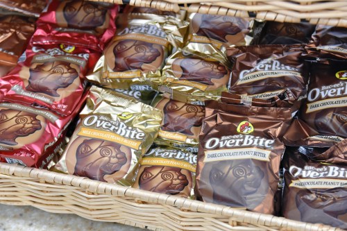 A basket filled with various chocolate candy packages, including dark chocolate and milk chocolate peanut butter options.