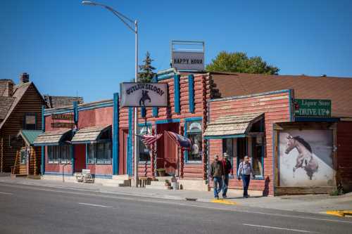 A colorful western-style building with a sign for "Outlaw Saloon" and a liquor store, set against a clear blue sky.