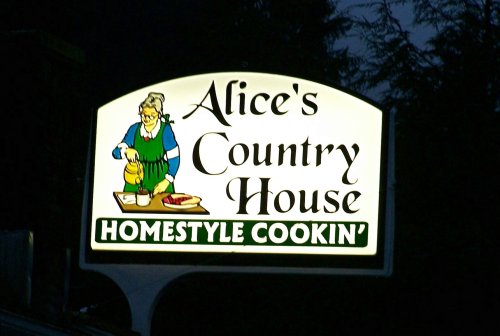 Sign for "Alice's Country House" featuring a woman cooking, with the tagline "Homestyle Cookin'."