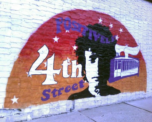 Colorful mural featuring the text "Positive 4th Street" with a silhouette and abstract designs in the background.