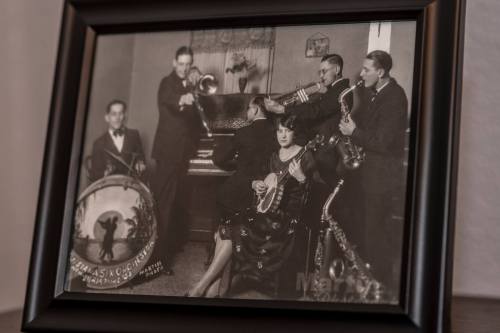 A vintage black-and-white photo of a jazz band with musicians playing instruments, including a piano and saxophone.