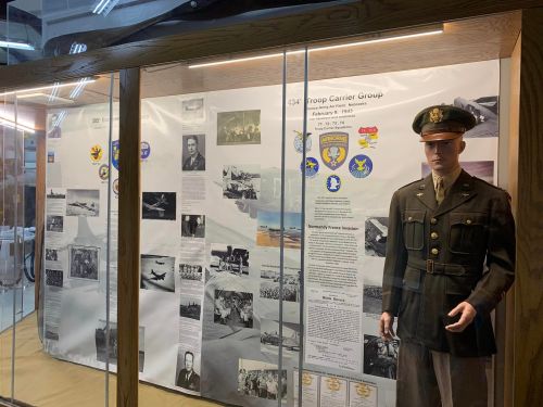 Display case featuring a military uniform and historical information about the 434 Troop Carrier Group.