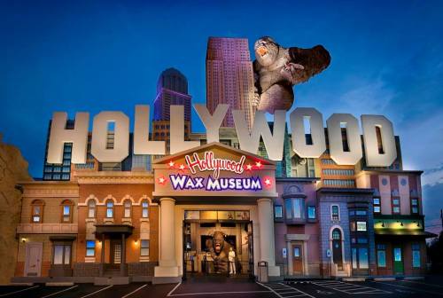 Exterior of the Hollywood Wax Museum, featuring large "HOLLYWOOD" letters and a giant gorilla statue.