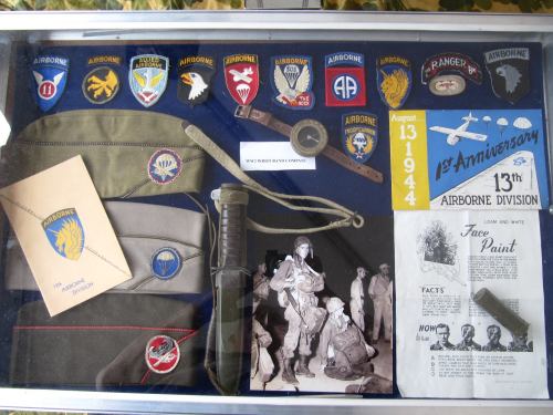 Display case featuring military insignia, a knife, and documents related to the 13th Airborne Division's history.