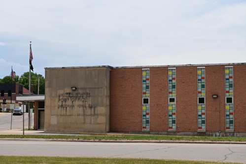 Exterior of the United States Post Office in Decorah, Iowa, featuring a brick facade and colorful window panels.
