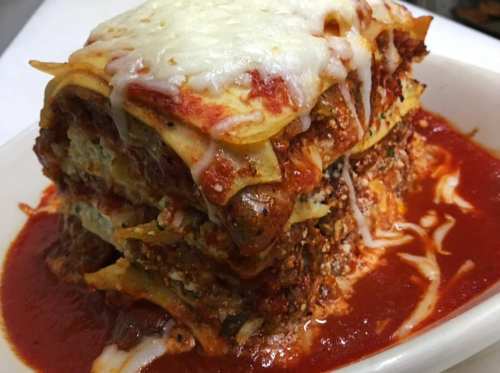 A delicious, layered lasagna topped with melted cheese and served in marinara sauce.