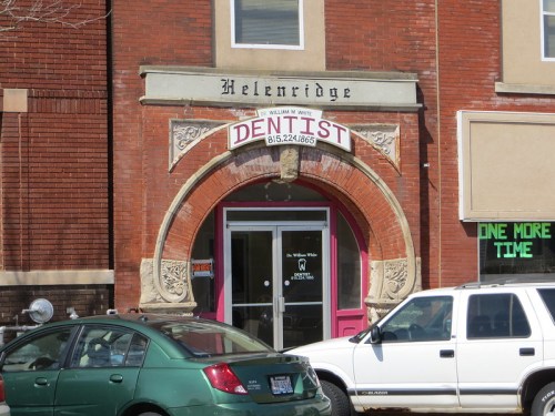 Sign for a dentist office with ornate architecture, featuring "Dentist" prominently displayed above the entrance.