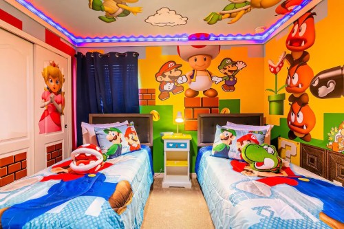 Colorful children's bedroom featuring Super Mario-themed decor, two beds with character bedding, and vibrant wall murals.