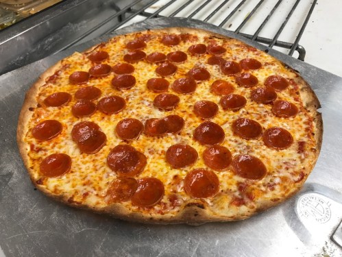 A freshly baked pepperoni pizza with a golden crust and evenly spaced pepperoni slices on top.