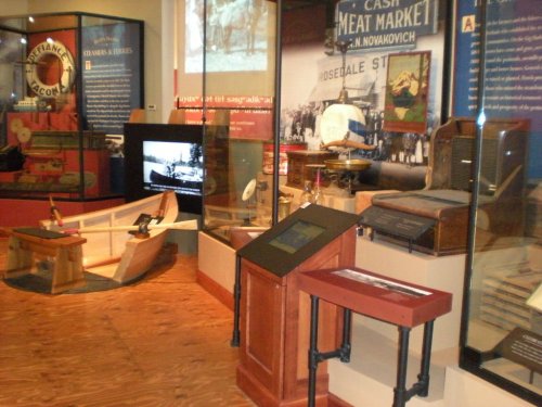Exhibit display featuring historical artifacts, photographs, and informational panels in a museum setting.