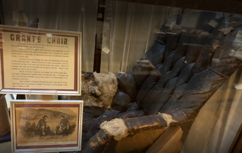 A worn, historic chair labeled "Grant's Chair" displayed with an informational plaque and an illustration below.