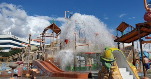 A colorful water park with slides and water features under a blue sky, creating a fun and playful atmosphere.