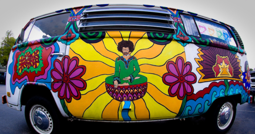 A colorful, psychedelic van featuring vibrant flowers and a meditating figure against a bright, swirling background.