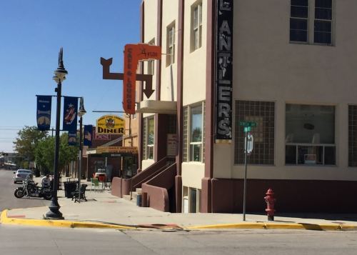 A street view featuring a diner, lounge, and colorful signage in a small town setting.