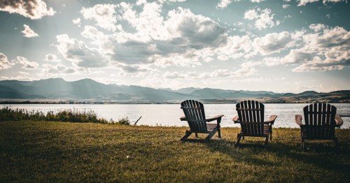 Three chairs sit along the shore of Ennis Lake in Montana.