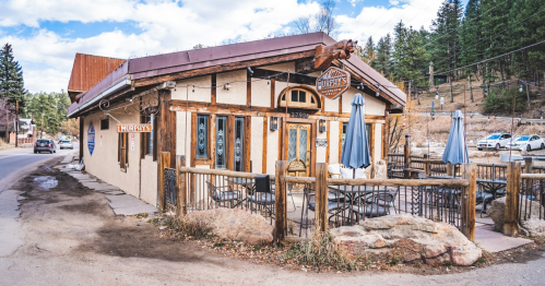 A charming restaurant with a rustic exterior, outdoor seating, and a sign reading "Murphy's," set in a wooded area.