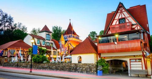 Charming alpine-style buildings with colorful facades and a vibrant sunset in a quaint town.