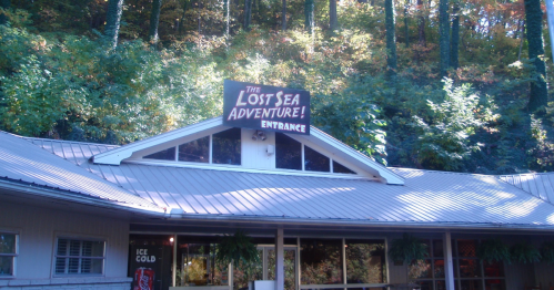 Sign for "The Lost Sea Adventure!" above the entrance of a building surrounded by trees and greenery.