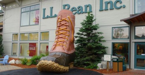 Giant boot sculpture outside L.L. Bean store, with trees and building in the background.