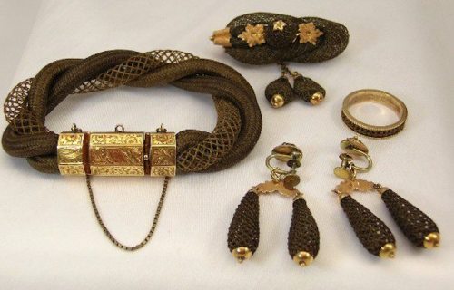 A collection of vintage jewelry including a bracelet, ring, and earrings with intricate designs in gold and brown tones.