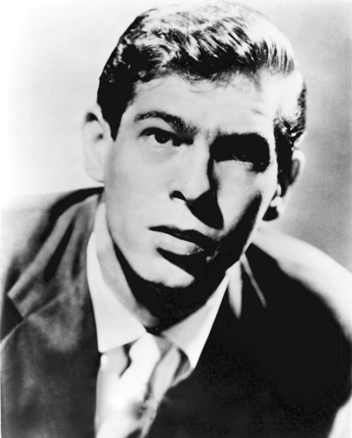 Black and white portrait of a young man in a suit, looking intently at the camera with a serious expression.