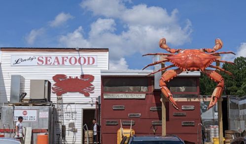 A seafood restaurant with a large crab sculpture outside, featuring a sign that reads "Lindy's Seafood."