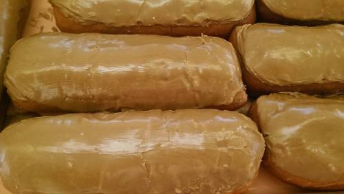 A close-up of several rectangular pastries covered in a smooth, shiny greenish-brown icing.