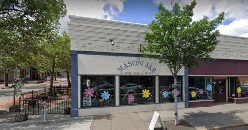 Exterior of "The Mason Jar," a bake shop and bistro, featuring colorful flower decorations on the windows.